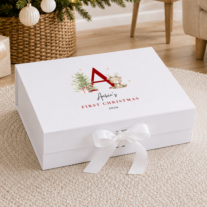 A white personalized Christmas gift box with a white ribbon bow, featuring a red monogram and &